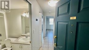 Kitchener multi-family for rent - A bathroom with a toilet, sink, and mirror.