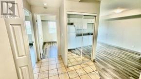 Kitchener multi-family for rent - A spacious room with a tiled floor and a glass door leading to another room.