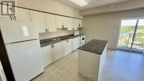 Waterloo multi-family for rent - A kitchen with white cabinets and a black granite countertop.