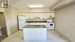 Waterloo multi-family for rent - A kitchen with a granite countertop and white appliances.