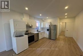 Toronto (Kensington-Chinatown) apartment for rent - A kitchen with white appliances and wooden floors.