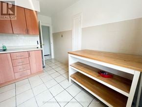 Toronto (Trinity-Bellwoods) apartment for rent - A kitchen with white tiles and wooden shelves.
