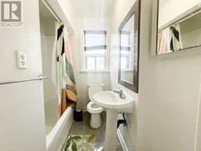 Toronto (Trinity-Bellwoods) apartment for rent - A white bathroom with a toilet, sink, and mirror.