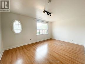 Toronto (Trinity-Bellwoods) apartment for rent - A room with a wooden floor and a window with a view of a building.