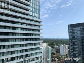 Toronto (Mount Pleasant West) condo for rent - A tall building with many windows is seen from a high vantage point.
