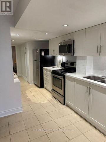 Vaughan (Patterson) apartment for rent - A kitchen with white cabinets and black appliances.