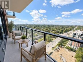 Toronto (Humber Heights) condo for rent - A balcony with two chairs and a table overlooking a cityscape.