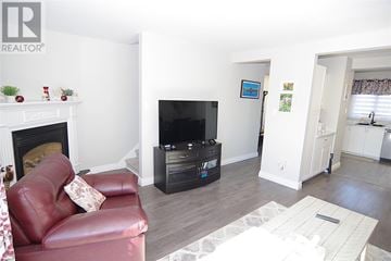 St. John's apartment for rent - A living room with a red couch and a fireplace.