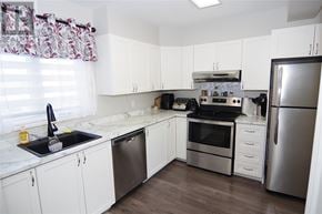 St. John's apartment for rent - A kitchen with white cabinets and stainless steel appliances.