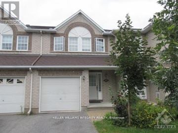 Ottawa townhouse for rent - A house with a garage and a tree in front.