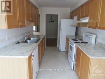 Ottawa townhouse for rent - A kitchen with wooden cabinets and a white refrigerator.