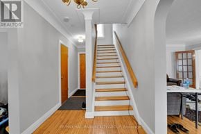 Ottawa duplex for rent - A hallway with a staircase and a chandelier.