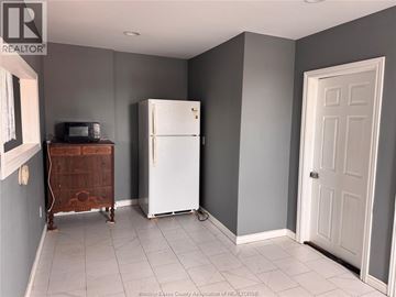 Essex apartment for rent - A kitchen with a white fridge and a wooden cabinet.