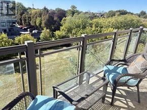 Toronto (Bathurst Manor) condo for rent - A balcony with a table and chairs overlooking a cityscape.