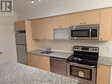 Toronto (Niagara) condo for rent - A kitchen with a stove, microwave, and refrigerator.