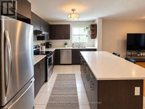 Ottawa fourplex for rent - A modern kitchen with a stainless steel refrigerator and dark wood cabinets.