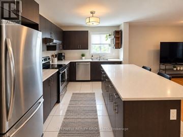 Ottawa fourplex for rent - A modern kitchen with a stainless steel refrigerator and dark wood cabinets.