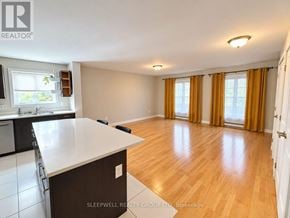 Ottawa fourplex for rent - A well-lit, spacious kitchen and living room with wooden flooring and white walls.