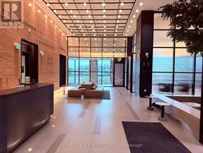 Oakville (Jm Joshua Meadows) condo for rent - A modern office lobby with a reception desk and a view of the city.