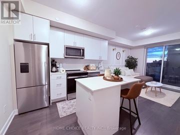 Oakville (Jm Joshua Meadows) condo for rent - A modern kitchen with white cabinets and a stainless steel refrigerator.