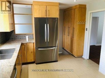 Oakville (Mo Morrison) apartment for rent - A kitchen with wooden cabinets and a stainless steel refrigerator.