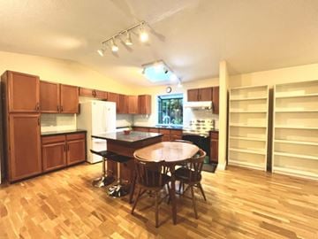 Surrey apartment for rent - A kitchen with wooden floors and a table with four chairs.