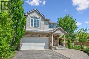 Kitchener apartment for rent - A house with a garage and a driveway is surrounded by greenery.