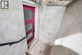 Kitchener apartment for rent - A red door is on the left side of a white wall.