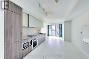 Toronto (Niagara) condo for rent - A modern kitchen with wooden cabinets and stainless steel appliances.