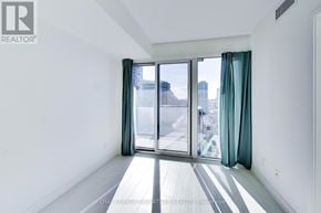 Toronto (Niagara) condo for rent - A white room with a sliding glass door leading to a balcony.