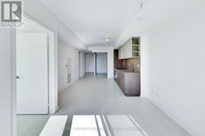Toronto (Niagara) condo for rent - A spacious, white-walled hallway with a wooden floor and a white door on the left.