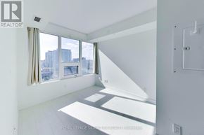 Toronto (Niagara) condo for rent - A white room with a window overlooking a cityscape.