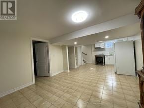 Toronto (Maple Leaf) apartment for rent - A spacious room with beige tiled flooring and a white door.