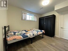 Toronto (Maple Leaf) apartment for rent - A bedroom with a bed, a window with curtains, and a black wardrobe.
