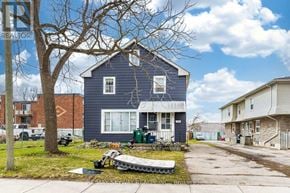Cambridge apartment for rent - A blue house with a white door and windows is surrounded by a white fence.