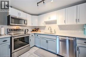 Waterloo condo for rent - A kitchen with white cabinets and stainless steel appliances.