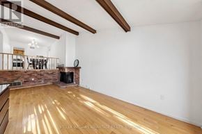 Toronto (Steeles) apartment for rent - A spacious living room with wooden floors and a fireplace.