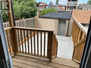 Toronto (Dovercourt-Wallace Emerson-Junction) duplex for rent - A wooden deck with a black roof and a glass door.