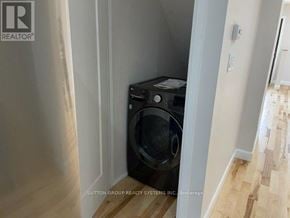 Toronto (Dovercourt-Wallace Emerson-Junction) duplex for rent - A black washing machine is tucked into a corner of a room.