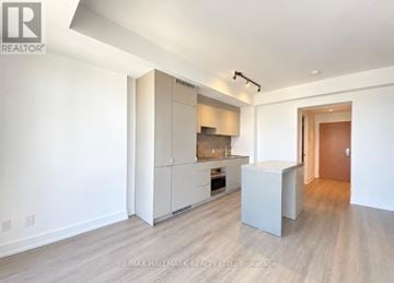 Toronto (Bay Street Corridor) condo for rent - A spacious kitchen with white cabinets and a wooden floor.
