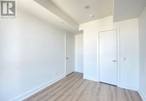 Toronto (Bay Street Corridor) condo for rent - A brokerage image of a white room with wood flooring and two doors.