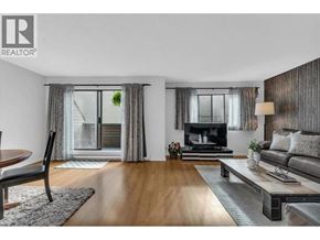 North Vancouver townhouse for rent - A modern living room with a wooden floor and a grey sofa.