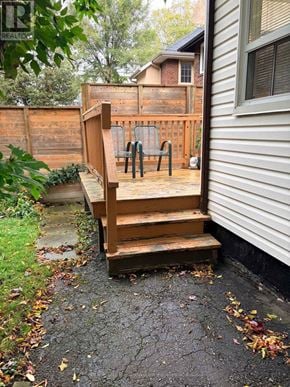 Toronto (Mimico) apartment for rent - A wooden staircase with a railing leads up to a backyard.