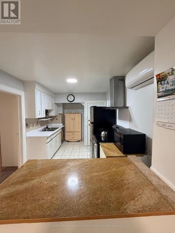 Toronto (Mimico) apartment for rent - A kitchen with a wooden counter top and white cabinets.