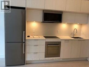 Toronto (Bayview Village) condo for rent - A modern kitchen with a refrigerator, microwave, oven, and sink.
