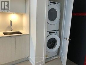 Toronto (Bayview Village) condo for rent - A small laundry room with a washer and dryer stacked on top of each other.