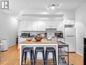Toronto (Niagara) condo for rent - A white kitchen with a table and chairs.