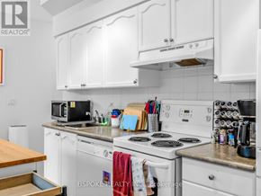 Toronto (Niagara) condo for rent - A kitchen with white cabinets and a white stove top oven.