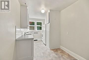 London South (South F) multi-family for rent - A white kitchen with a sink and a window.