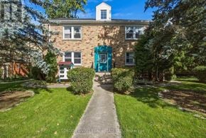London South (South F) multi-family for rent - A brick building with a blue door and a green bush.